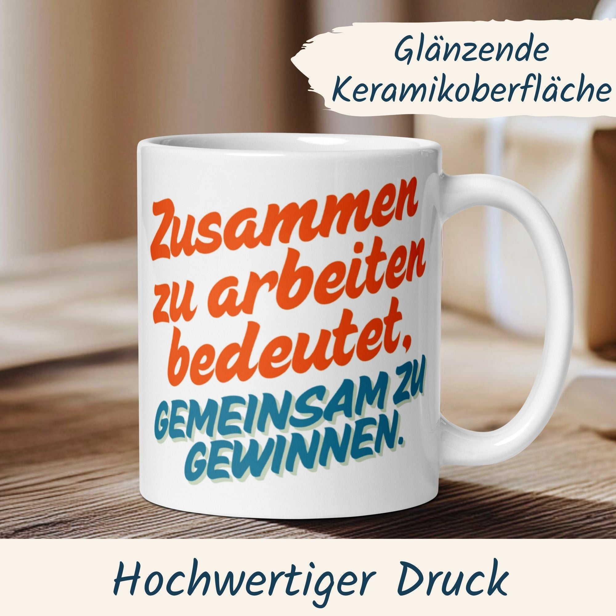 Weiße Keramiktasse mit Spruch "Zusammen zu arbeiten bedeutet, gemeinsam zu gewinnen" auf Holzoberfläche.