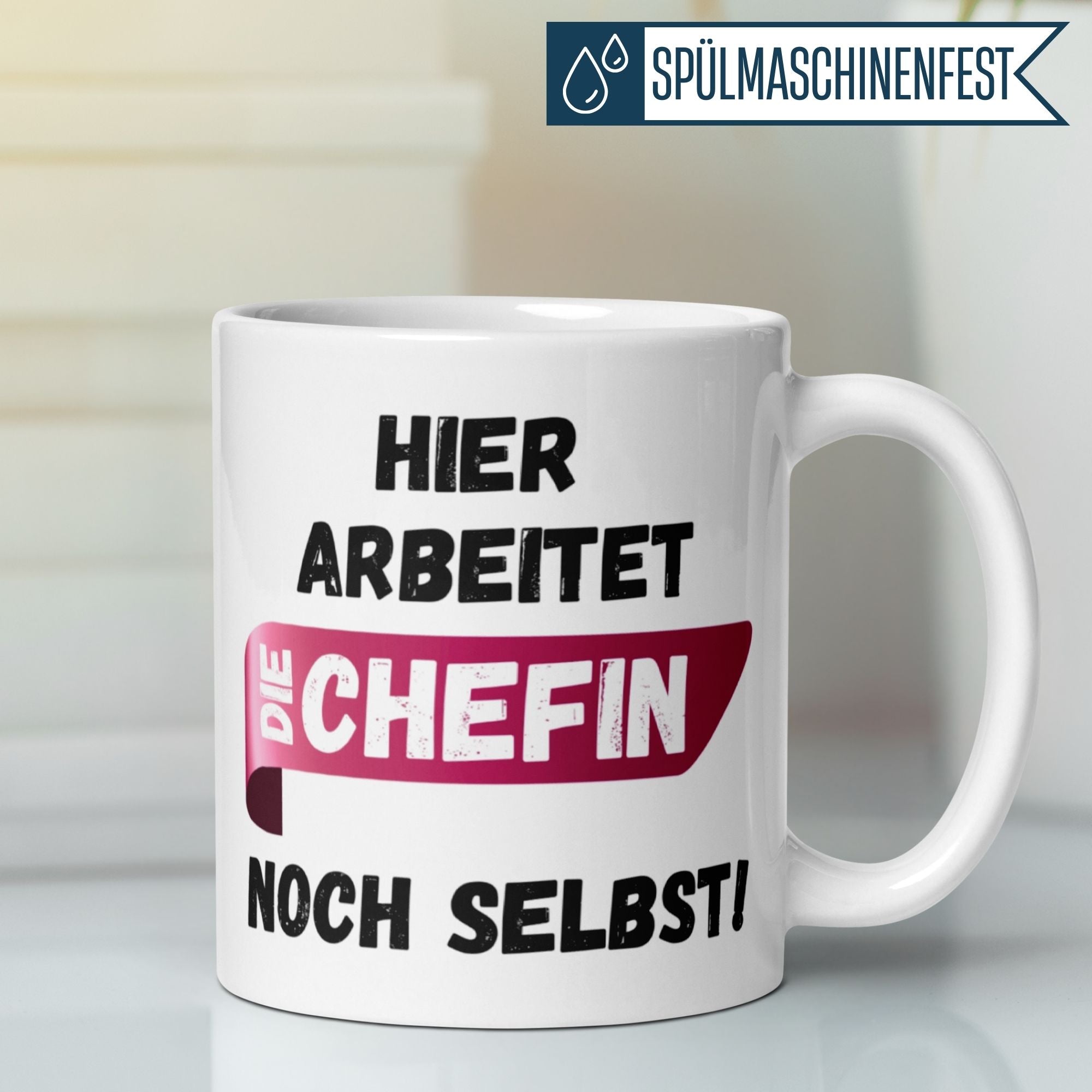Momentals® Tasse für Chefin mit humorvollem Spruch "Hier arbeitet die Chefin noch selbst!" in Pink-Schwarz.