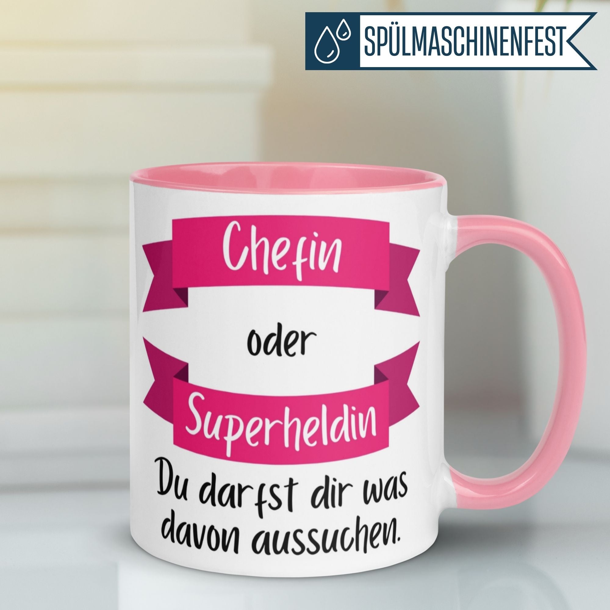 Momentals® Chefin Tasse mit Spruch: 'Chefin oder Superheldin - Du darfst dir was aussuchen' in pink und weiß.