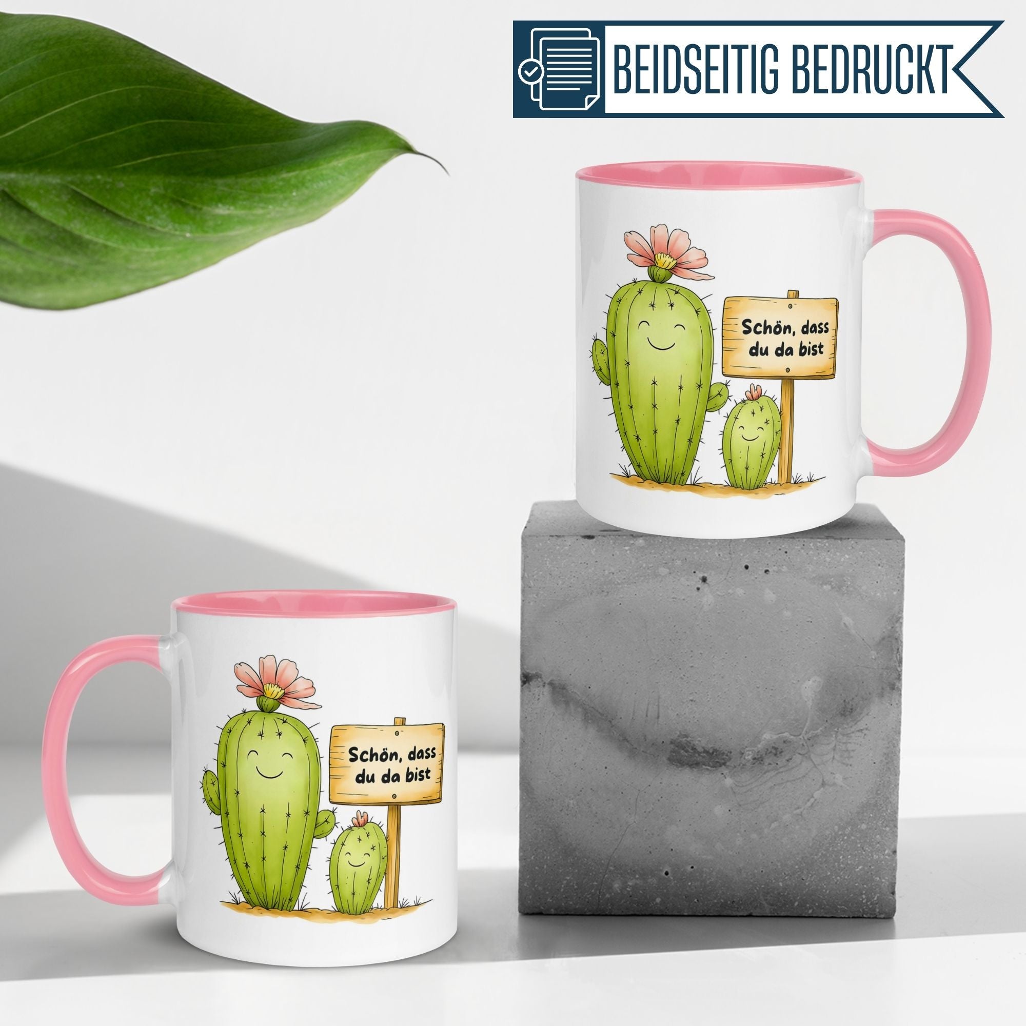 Momentals Tasse mit Kaktus-Motiv und Spruch 'Schön, dass du da bist' auf einem grauen Block.
