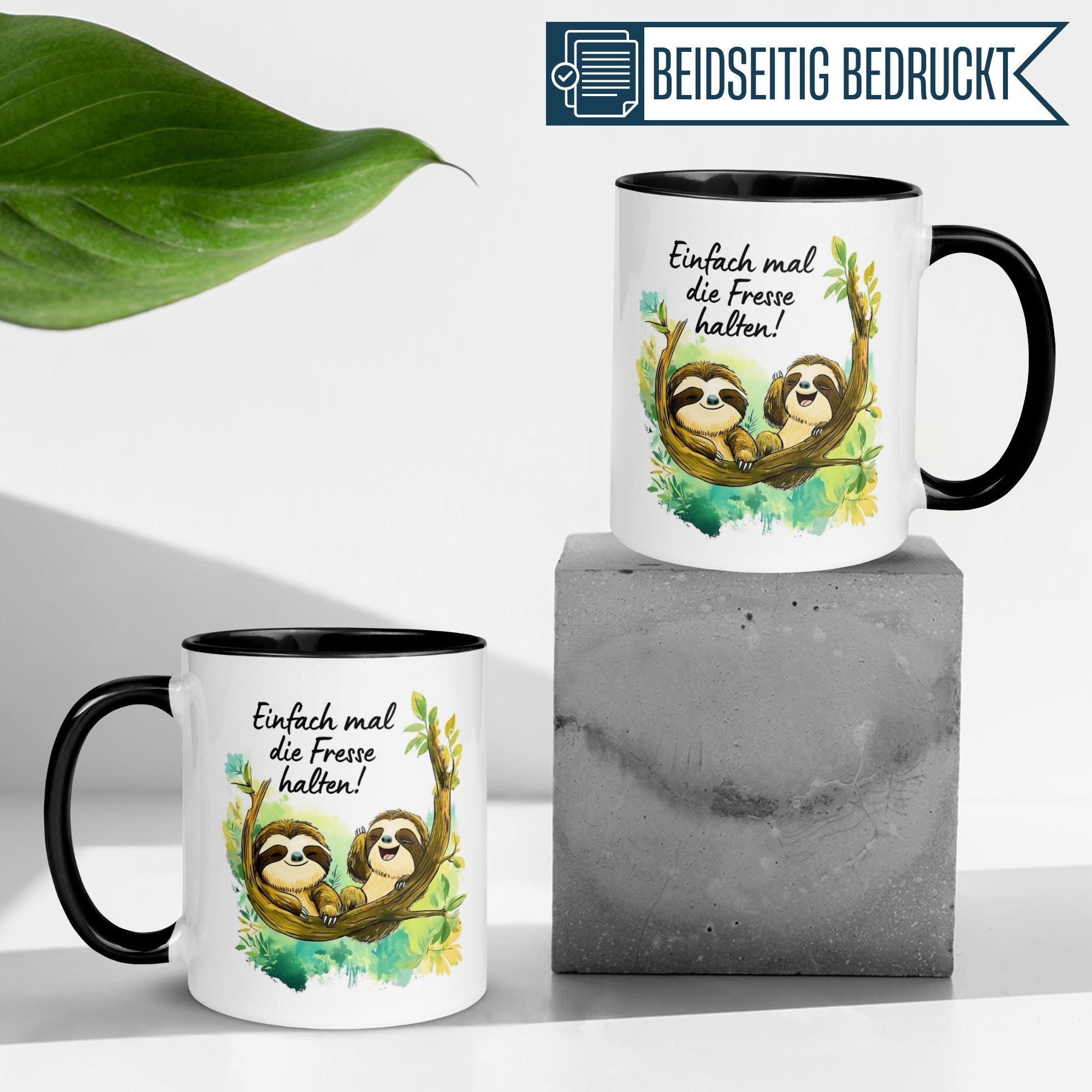 Momentals Tasse mit Faultieren und Spruch "Einfach mal die Fresse halten!" auf Betonuntergrund.