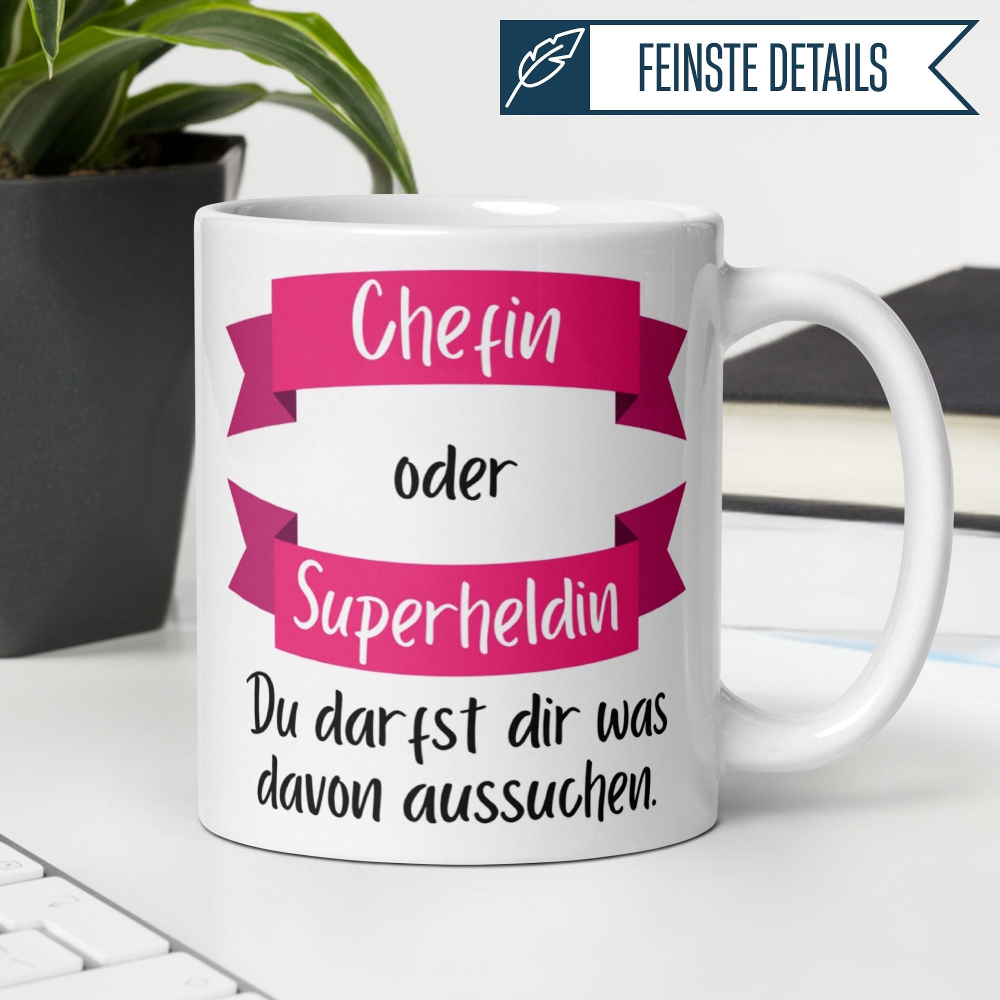 Momentals Tasse mit Spruch "Chefin oder Superheldin – Du darfst dir was davon aussuchen" in pink und weiß.