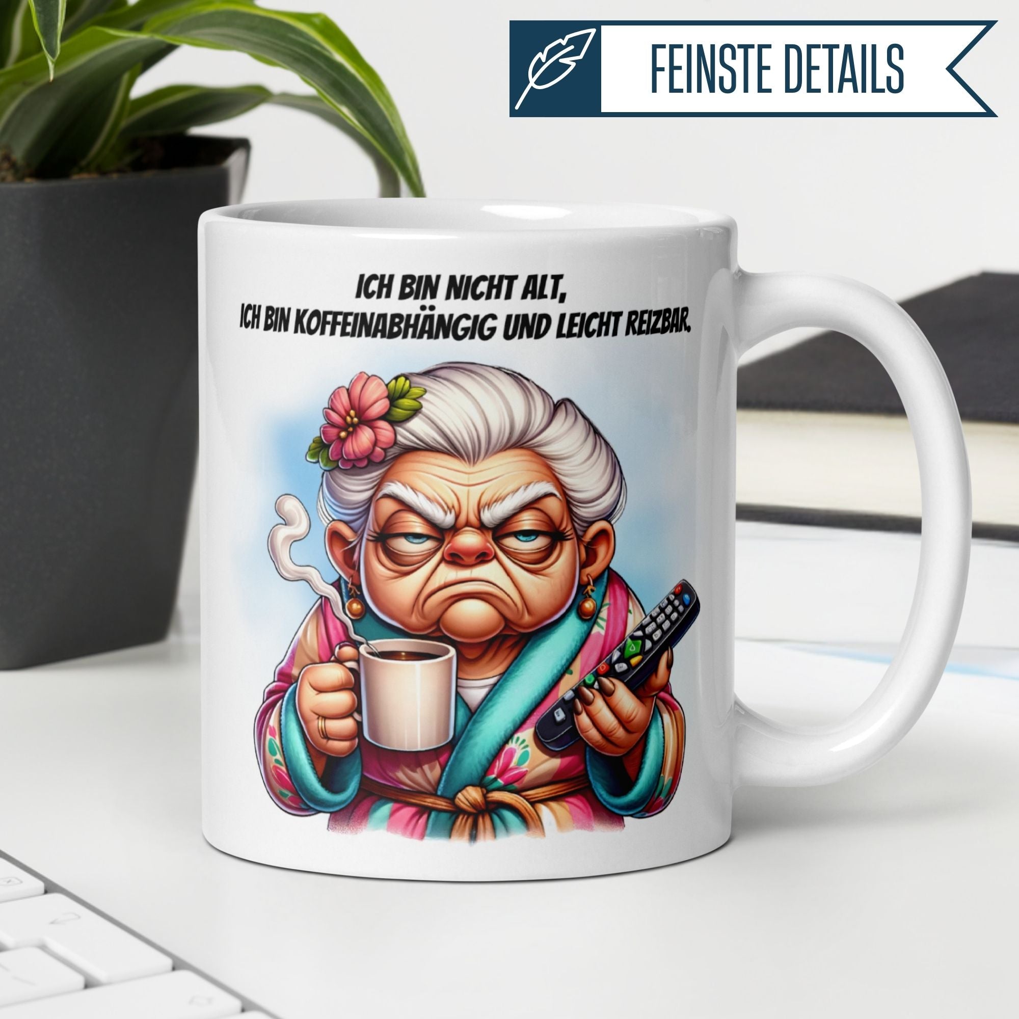 Humorous Momentals mug featuring grumpy grandma with coffee and remote, saying 'Ich bin nicht alt, ich bin koffeinabhängig.'