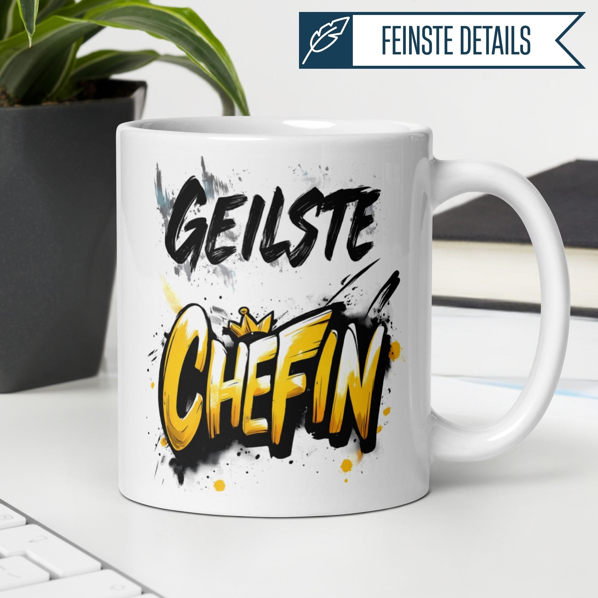 Momentals® Tasse "Geilste Chefin" in Graffiti-Design mit goldgelber Schrift und Farbspritzern.