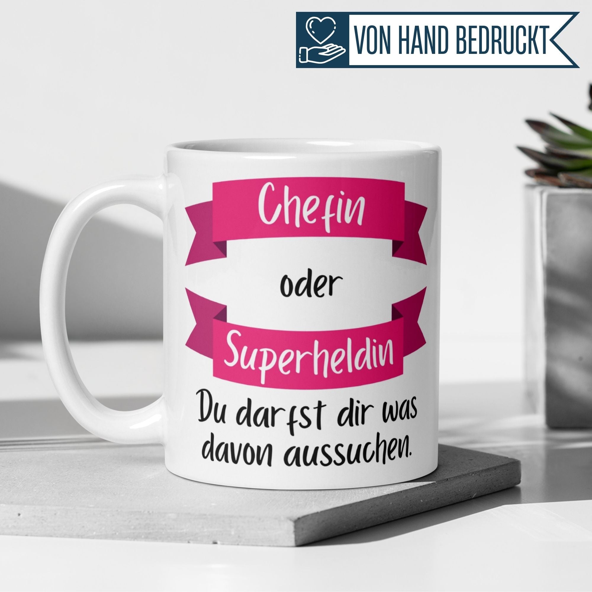 Momentals Tasse Chefin mit Spruch "Chefin oder Superheldin – Du darfst dir was aussuchen" in pinkem Design.