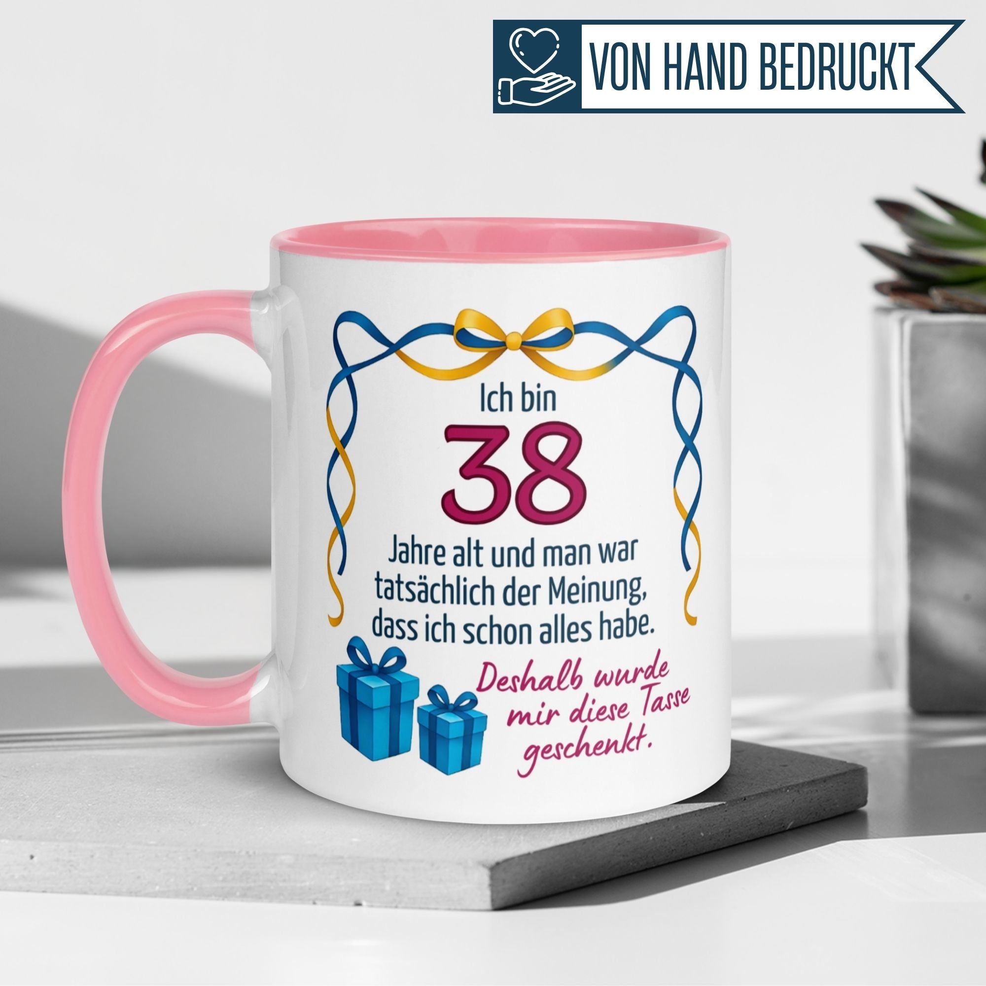 Momentals® Tasse für den 38. Geburtstag mit humorvollem Spruch und Geschenkmotiv in Pink.