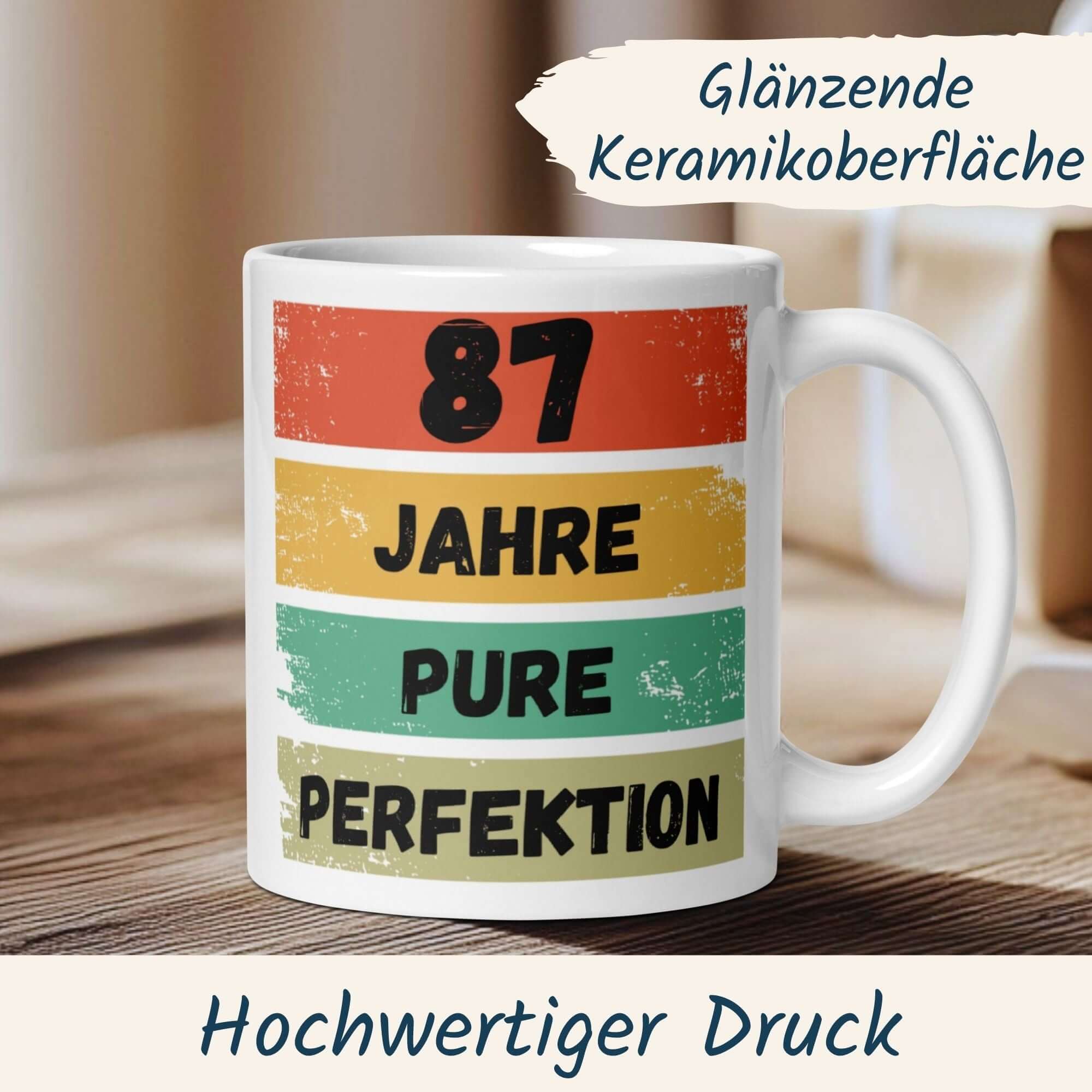 Momentals® Tasse zum 87. Geburtstag mit Retro-Design und Spruch "87 Jahre pure Perfektion" auf Keramikoberfläche.