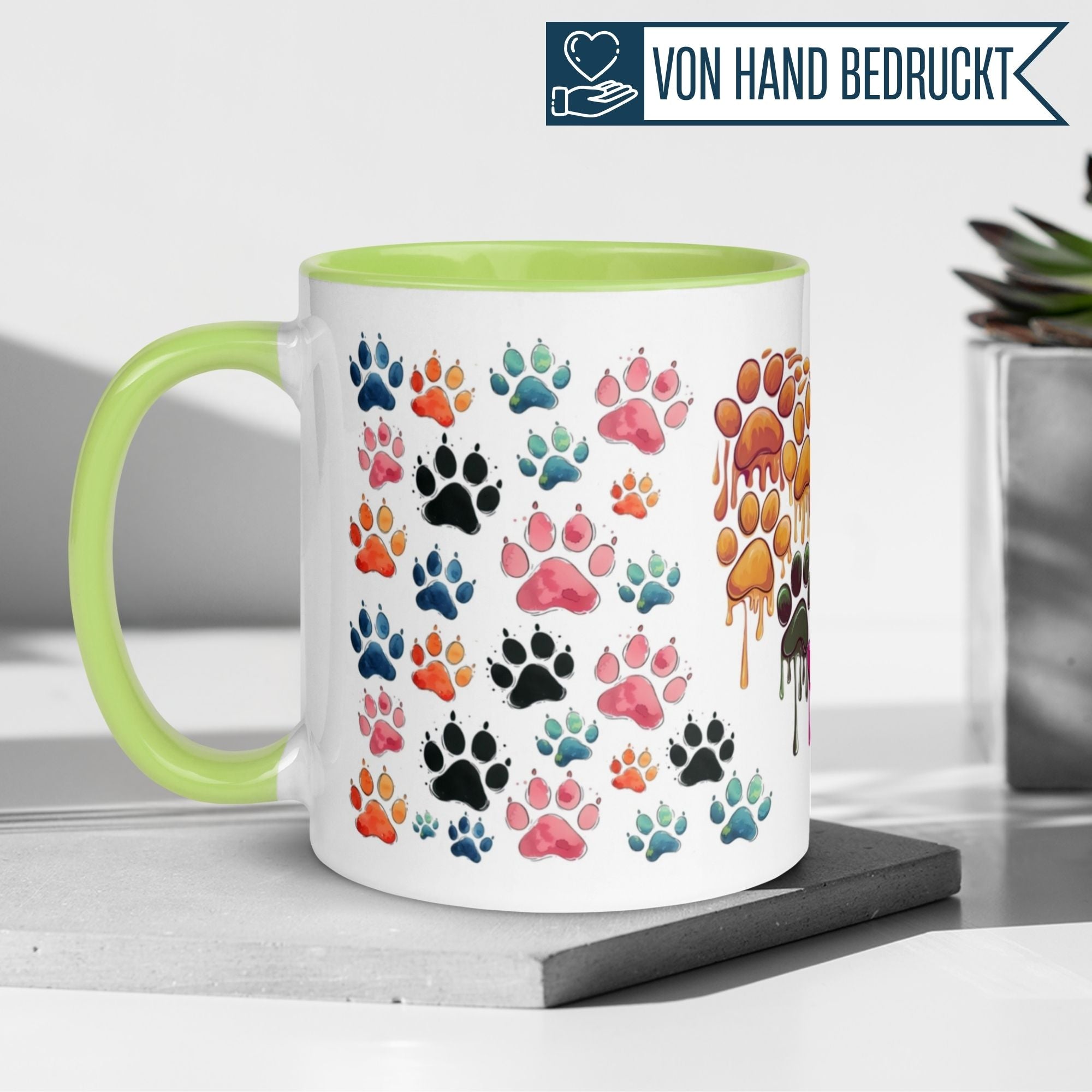 Momentals Tasse mit bunten Katzenpfoten-Design auf hellem Hintergrund für Katzenliebhaber.