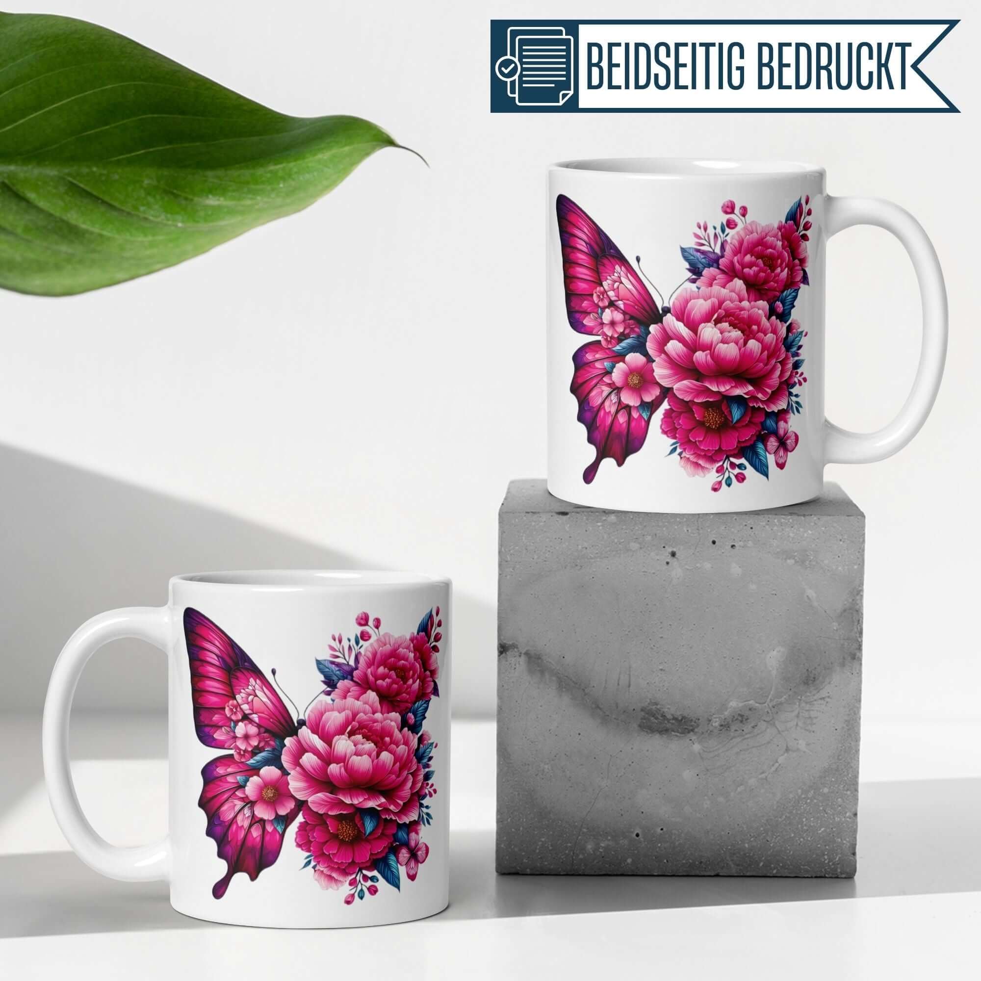Elegante Momentals® Tasse mit Schmetterling und Blumenillustration in Pink und Blau, beidseitig bedruckt.