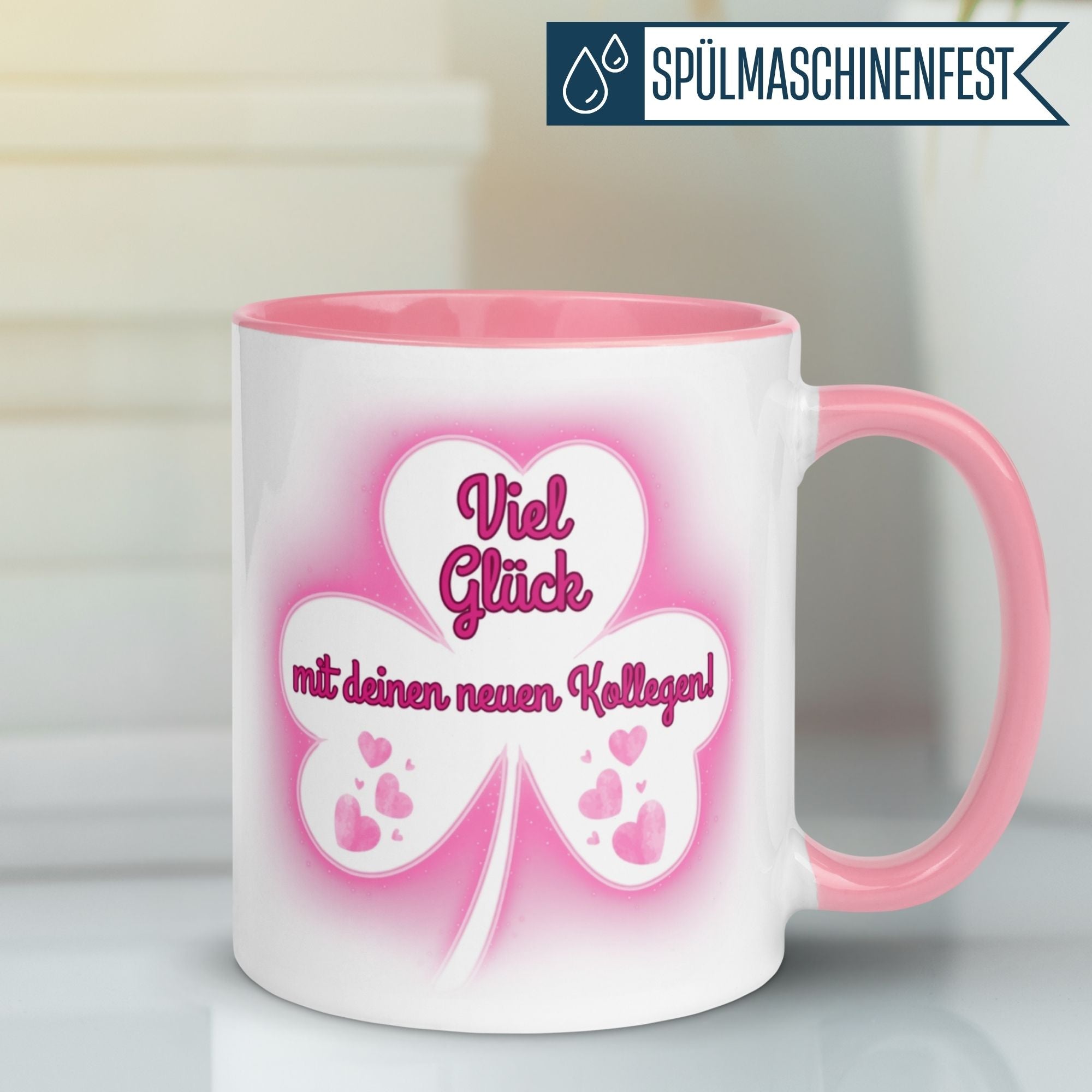 Momentals Tasse mit Spruch "Viel Glück mit deinen neuen Kollegen!" und rosafarbenem Kleeblatt-Motiv.