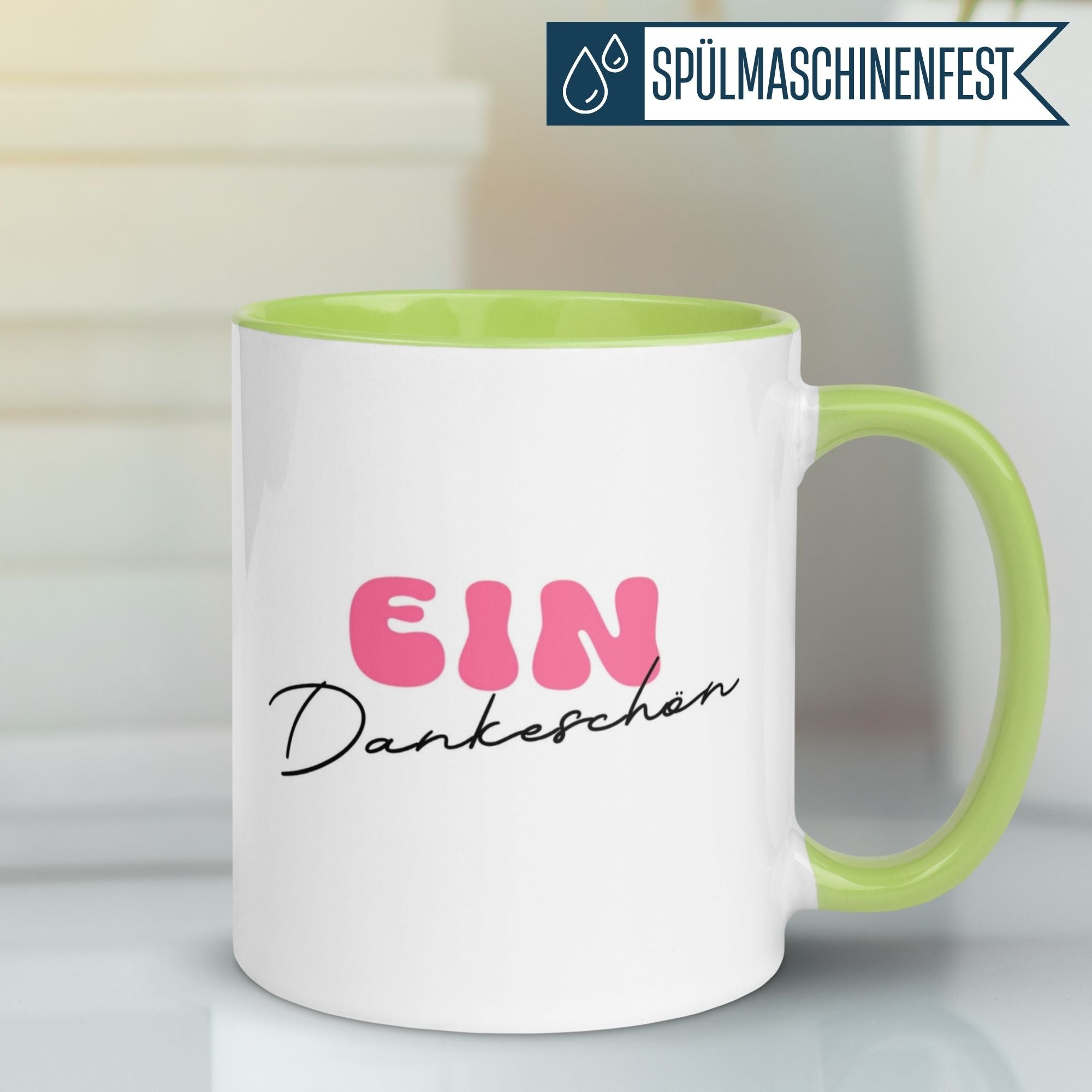 Momentals Tasse mit minimalistischer Schrift "Ein Dankeschön" in Pink und grünem Henkel.