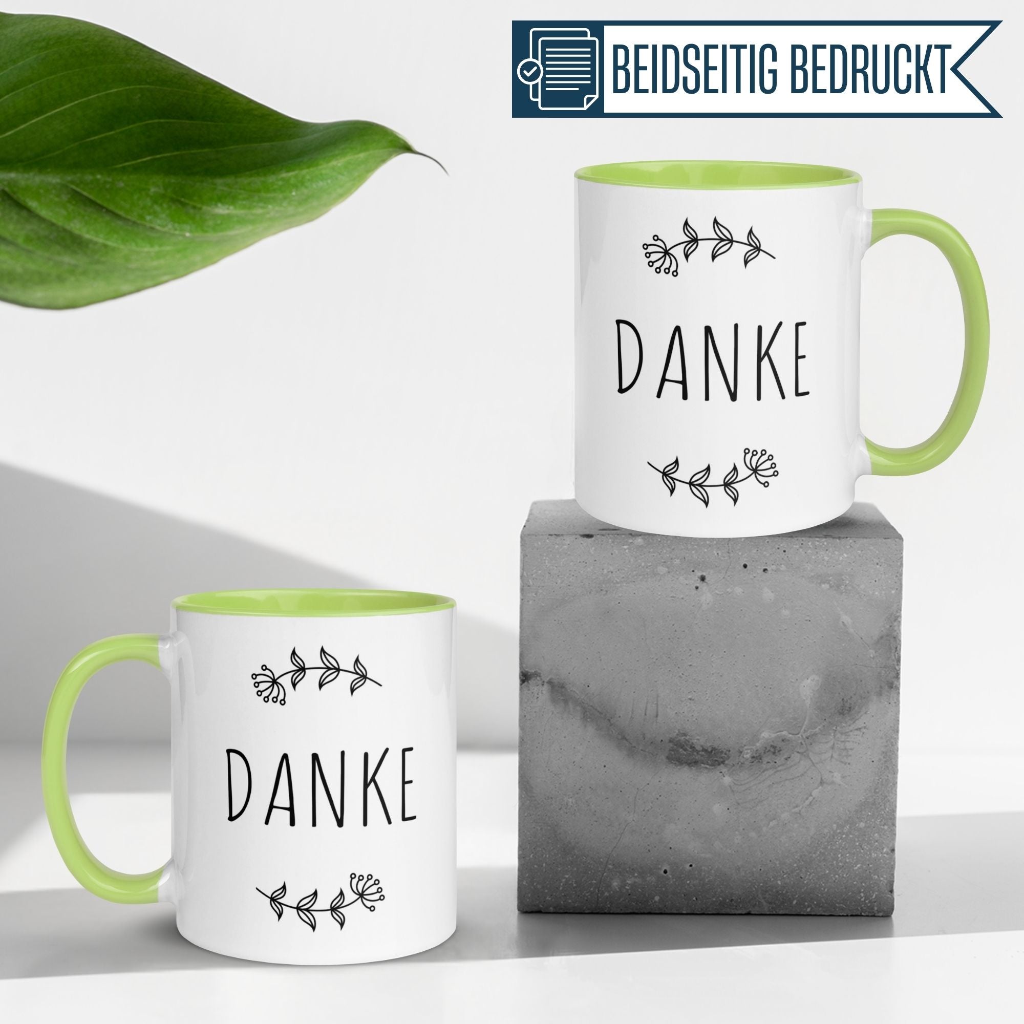Zwei Tassen von Momentals mit dem Wort 'DANKE' und floralen Motiven, minimalistisches Design.