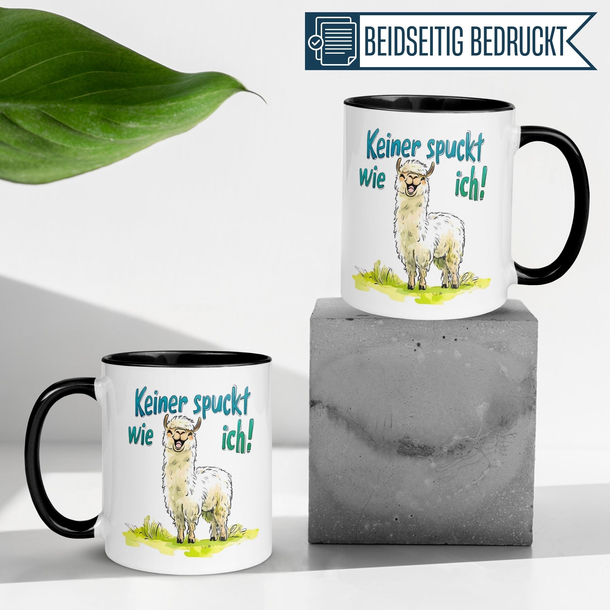 Momentals Tasse mit Lama-Motiv und Spruch "Keiner spuckt wie ich" auf Betonunterlage.