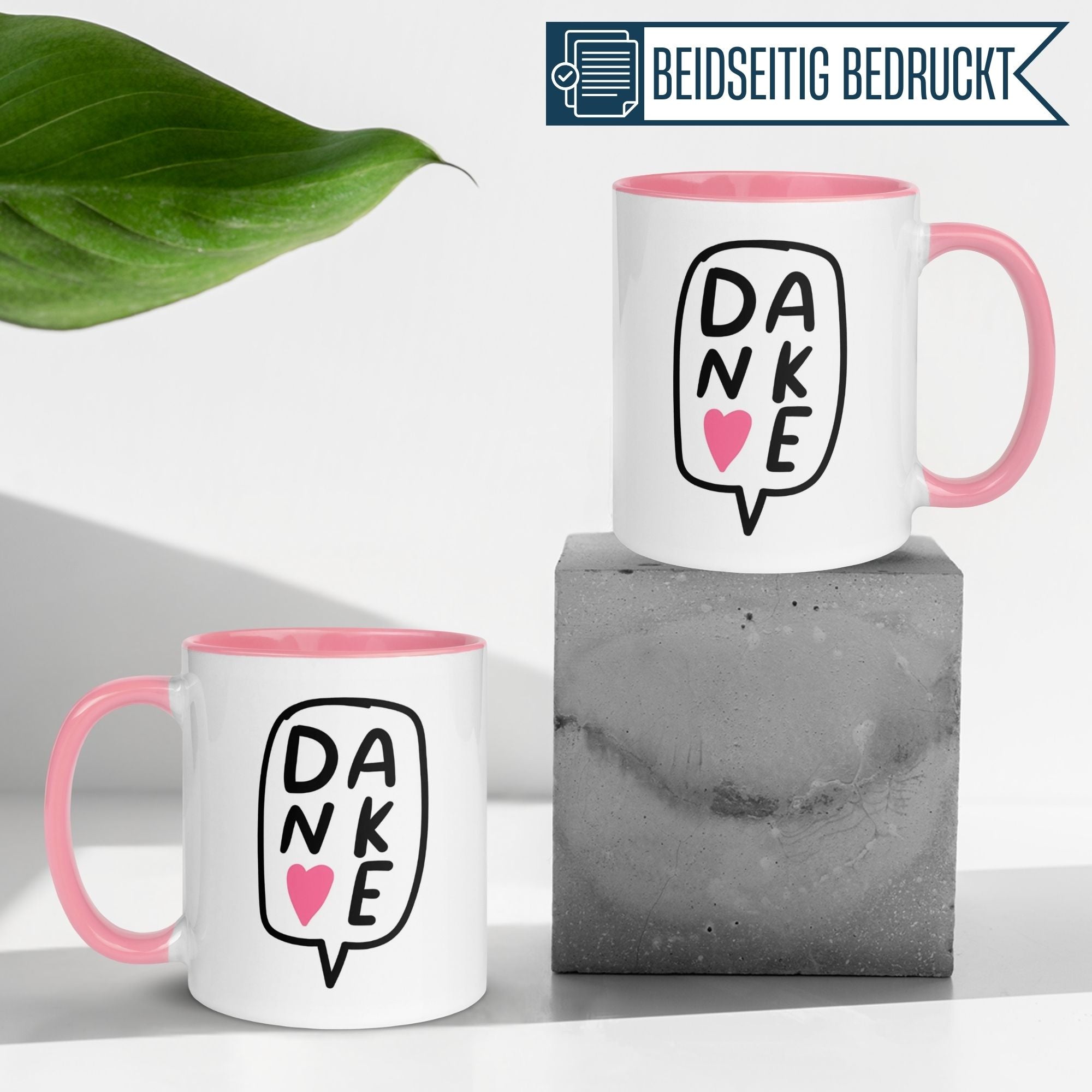 Momentals Tasse Dankeschön mit Herz in Sprechblase, pinker Henkel auf grauem Beton.