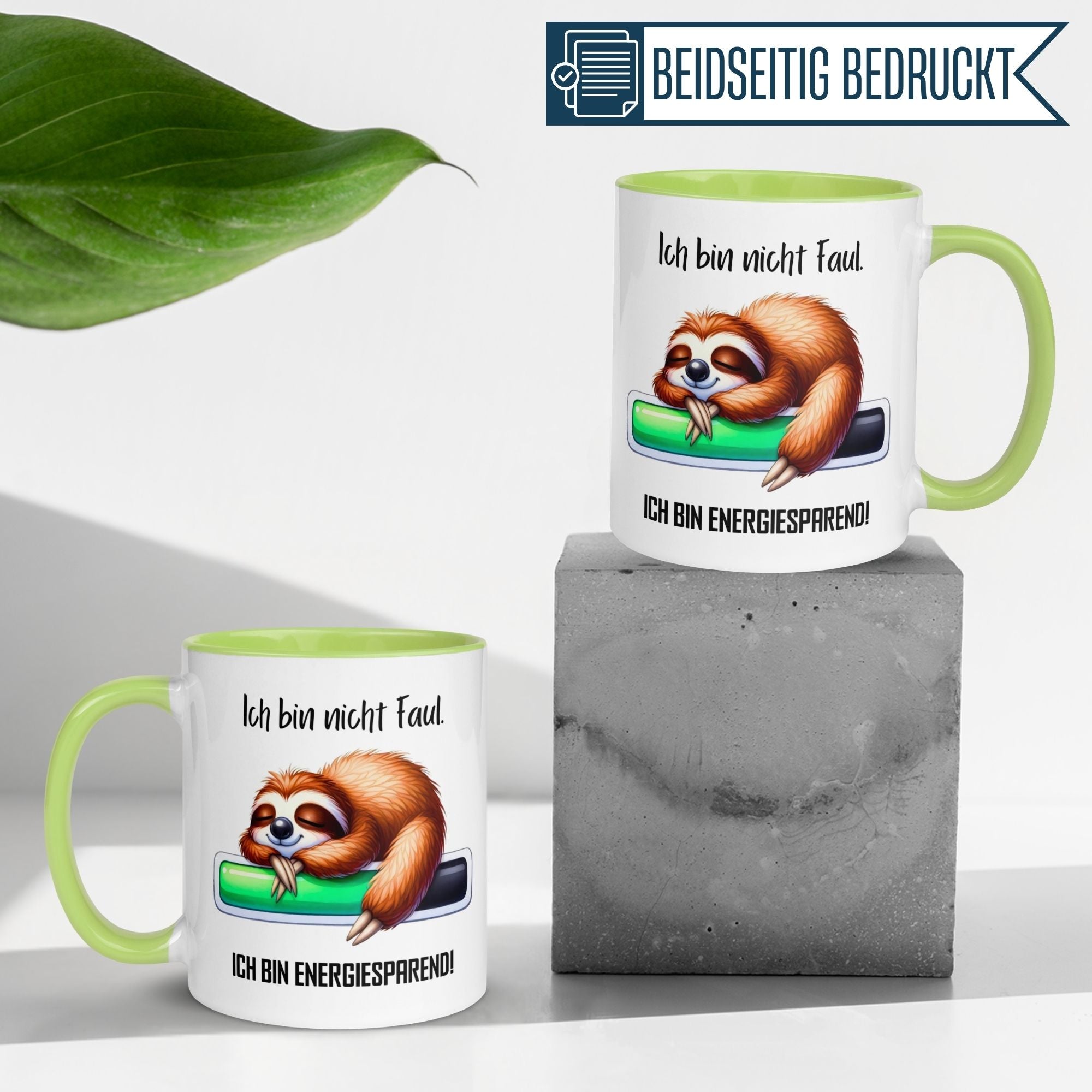 Momentals Tasse mit Faultier und Spruch "Ich bin nicht faul - ich bin energiesparend!" auf grünem Hintergrund.