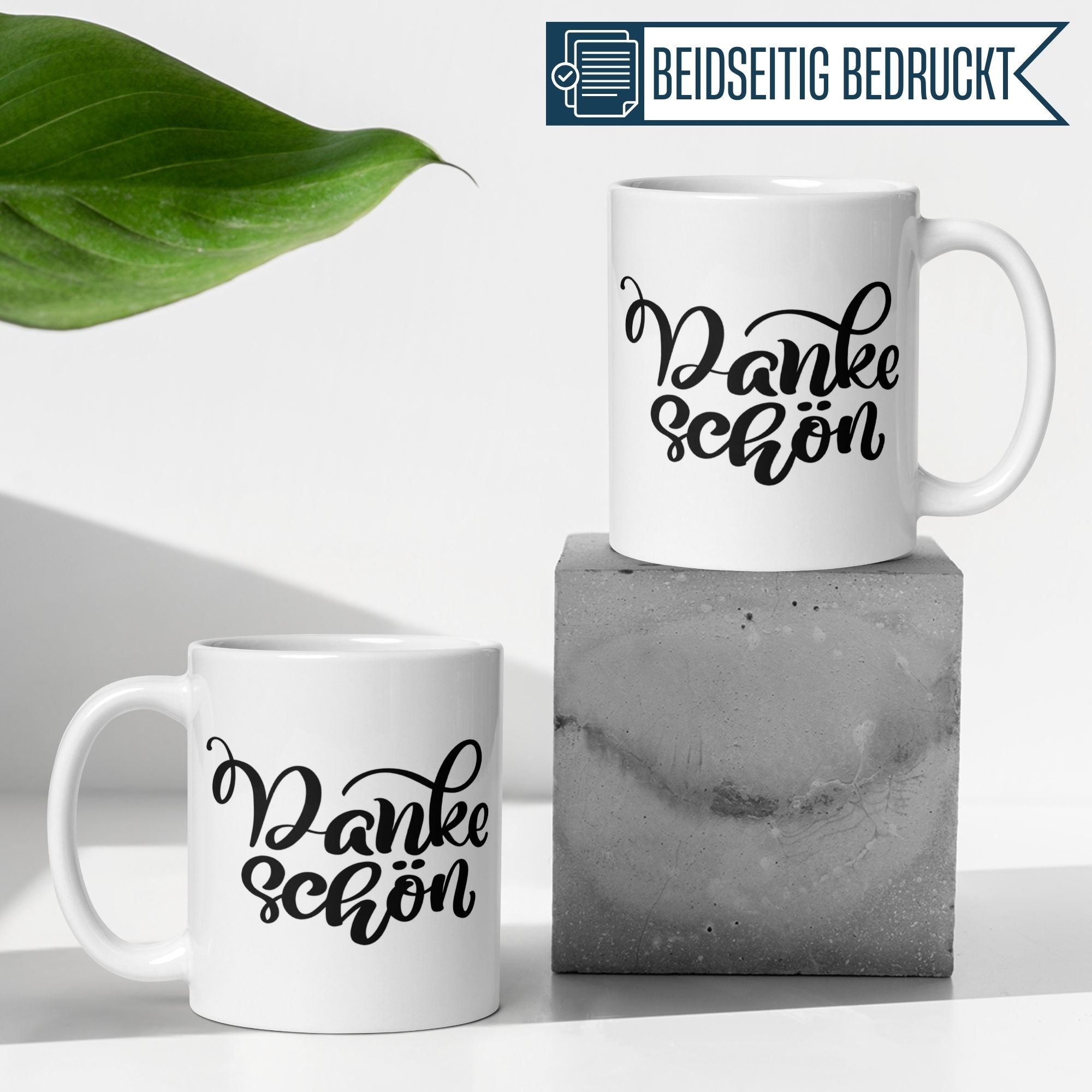 Elegante Tassen mit Handlettering "Danke schön" auf einem modernen Betonblock, ideal als stilvolles Dankeschön-Geschenk.