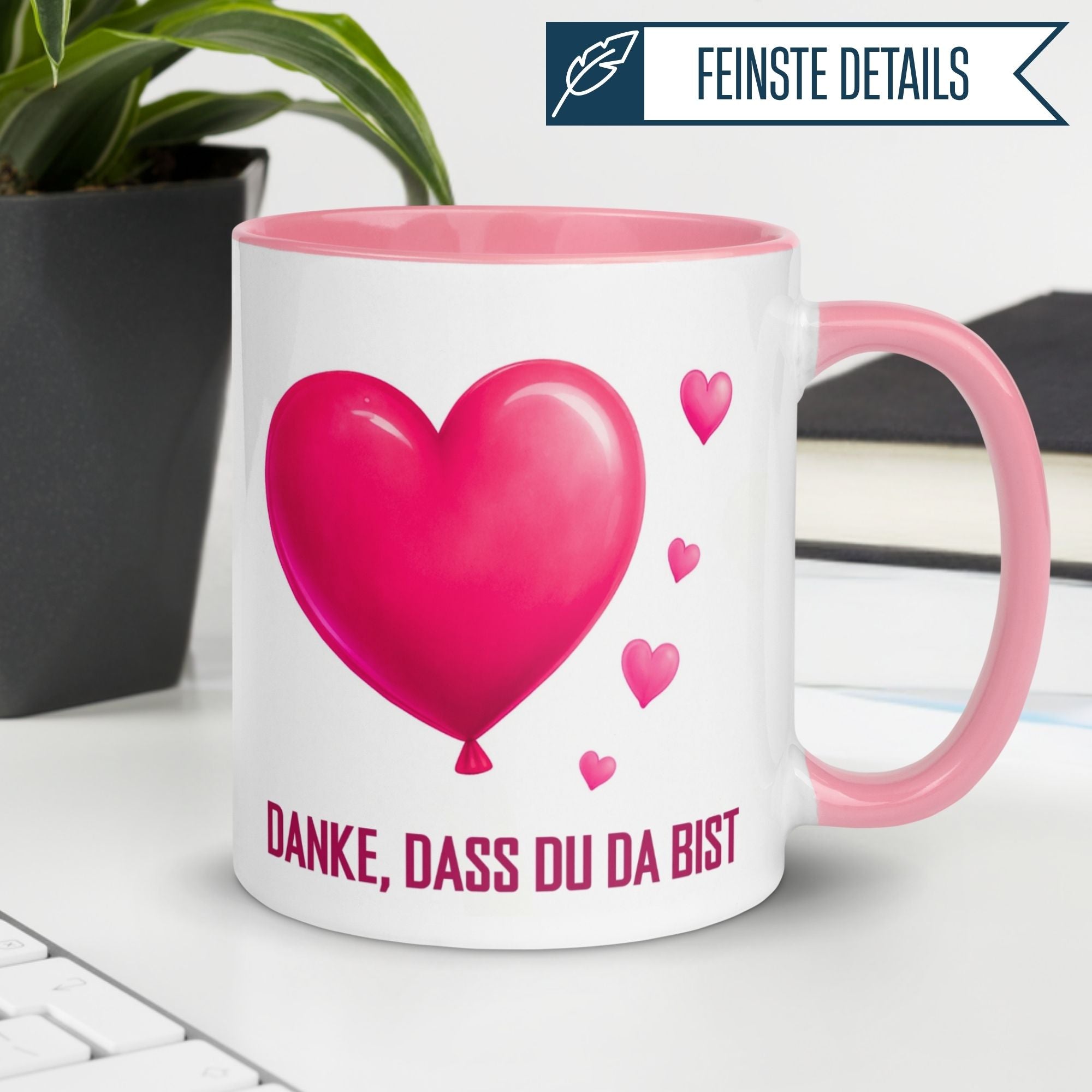 Momentals Tasse mit Herzballon-Motiv und Schriftzug "Danke, dass du da bist" auf einem Schreibtisch