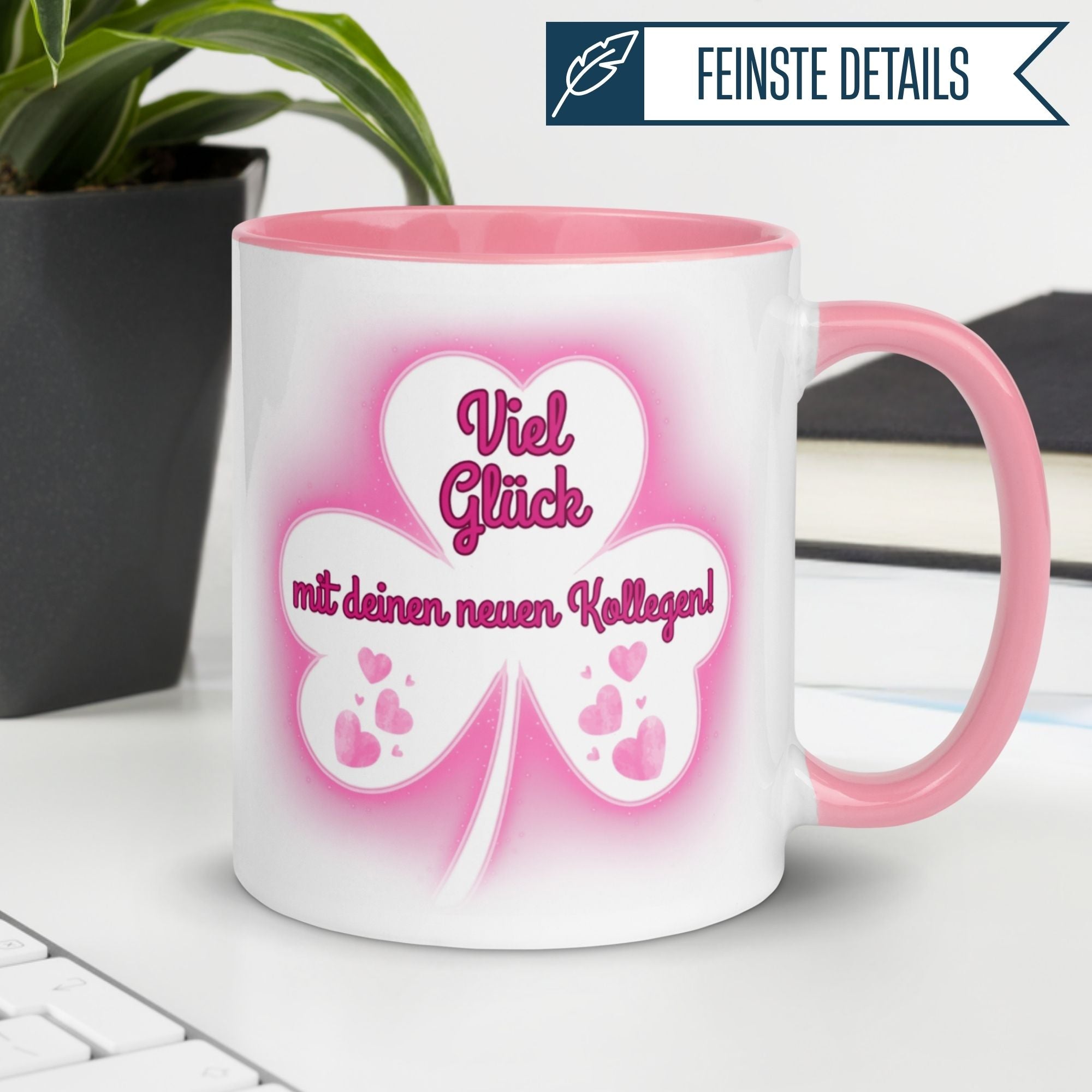 Momentals Tasse mit Spruch ‚Viel Glück mit deinen neuen Kollegen!‘ und rosafarbenem Kleeblatt-Motiv.