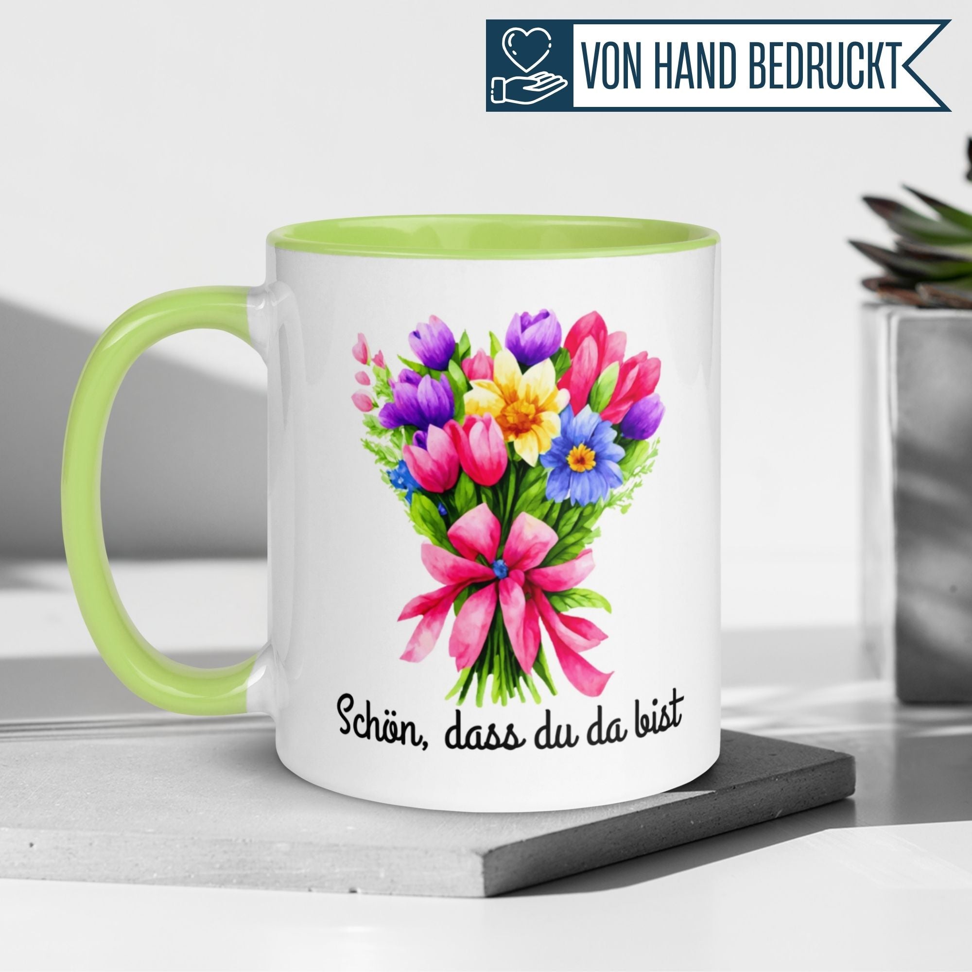 Momentals Tasse mit Blumenmotiv und der Aufschrift "Schön, dass du da bist" in lebhaftem Design.