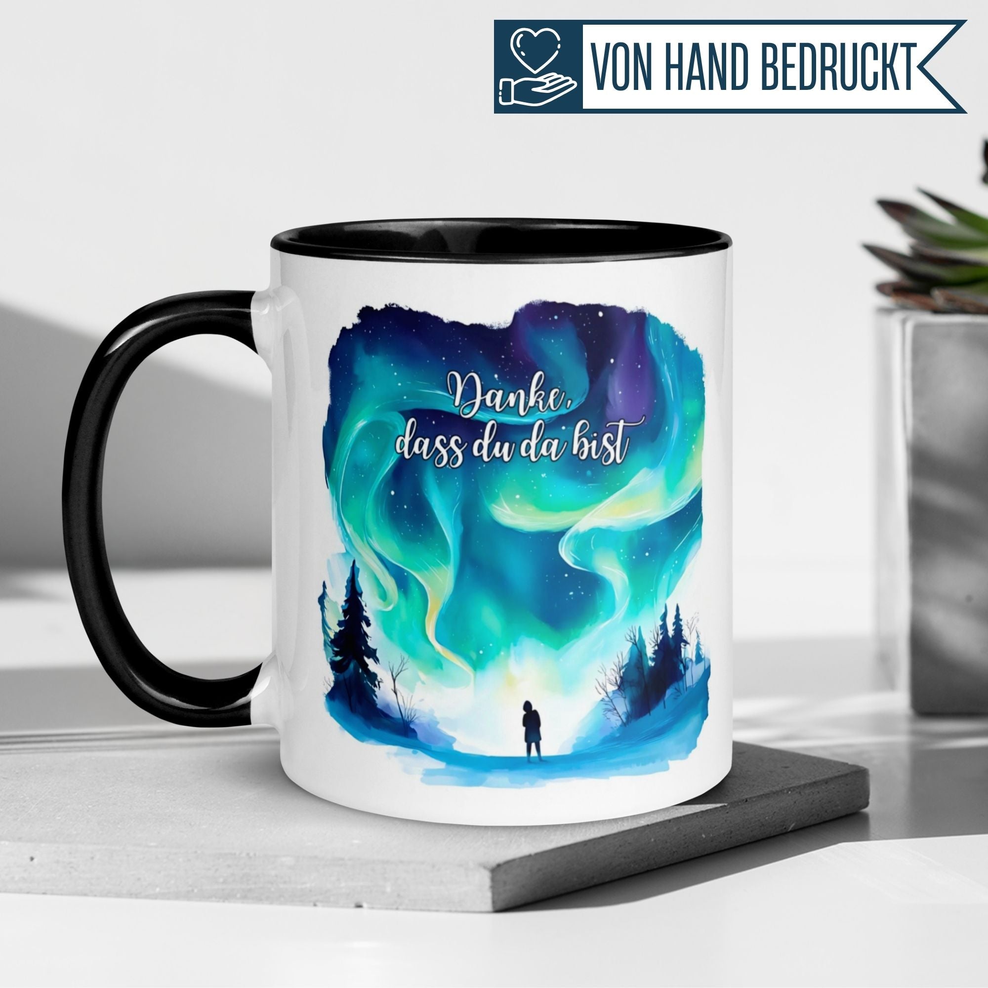 Schwarze Tasse mit Nordlicht-Motiv und der Aufschrift "Danke, dass du da bist" für Wertschätzung in jeder Kaffeepause.