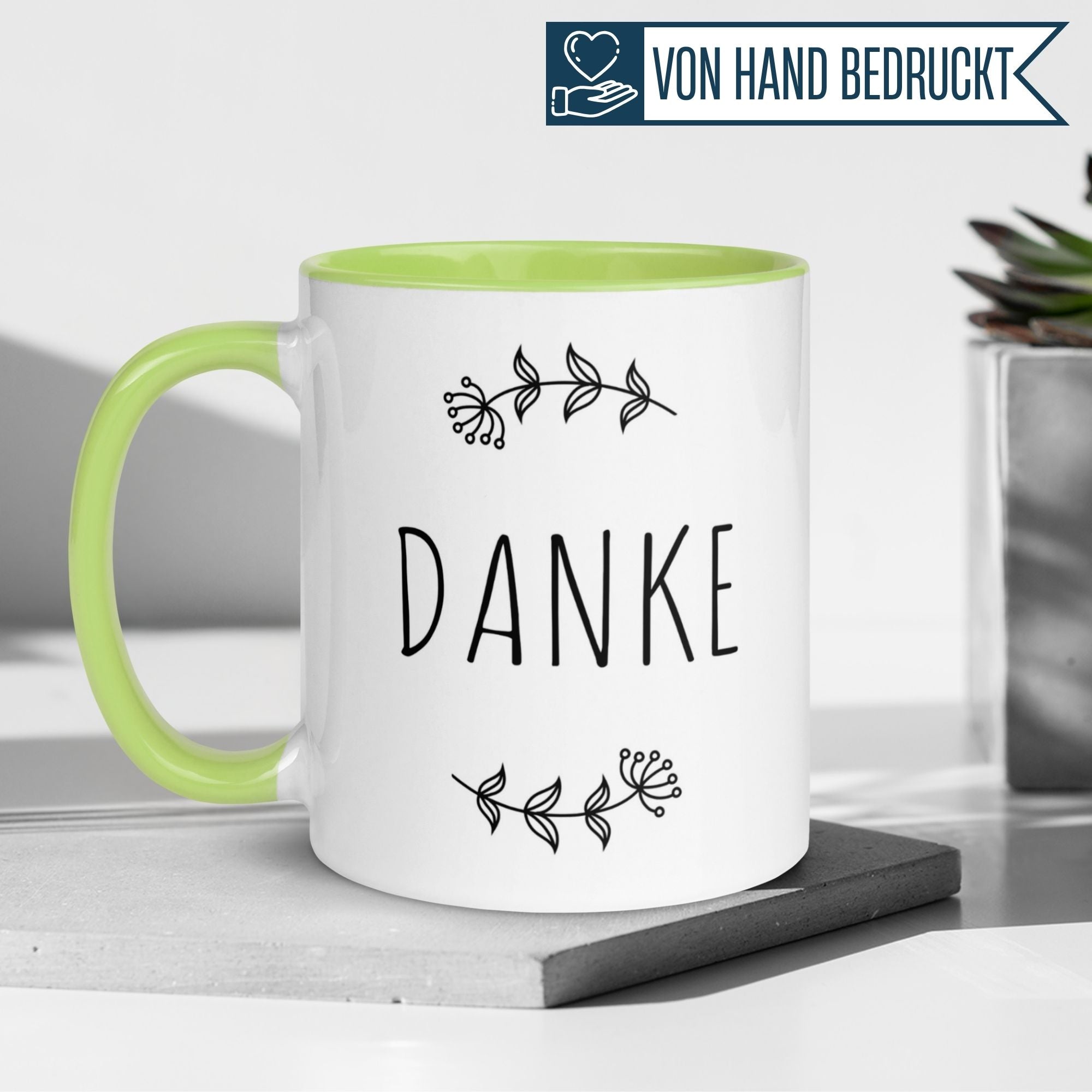 Momentals Tasse mit dem Wort 'DANKE' und floralem Design, stilvoll für Geschenke und Wertschätzung.