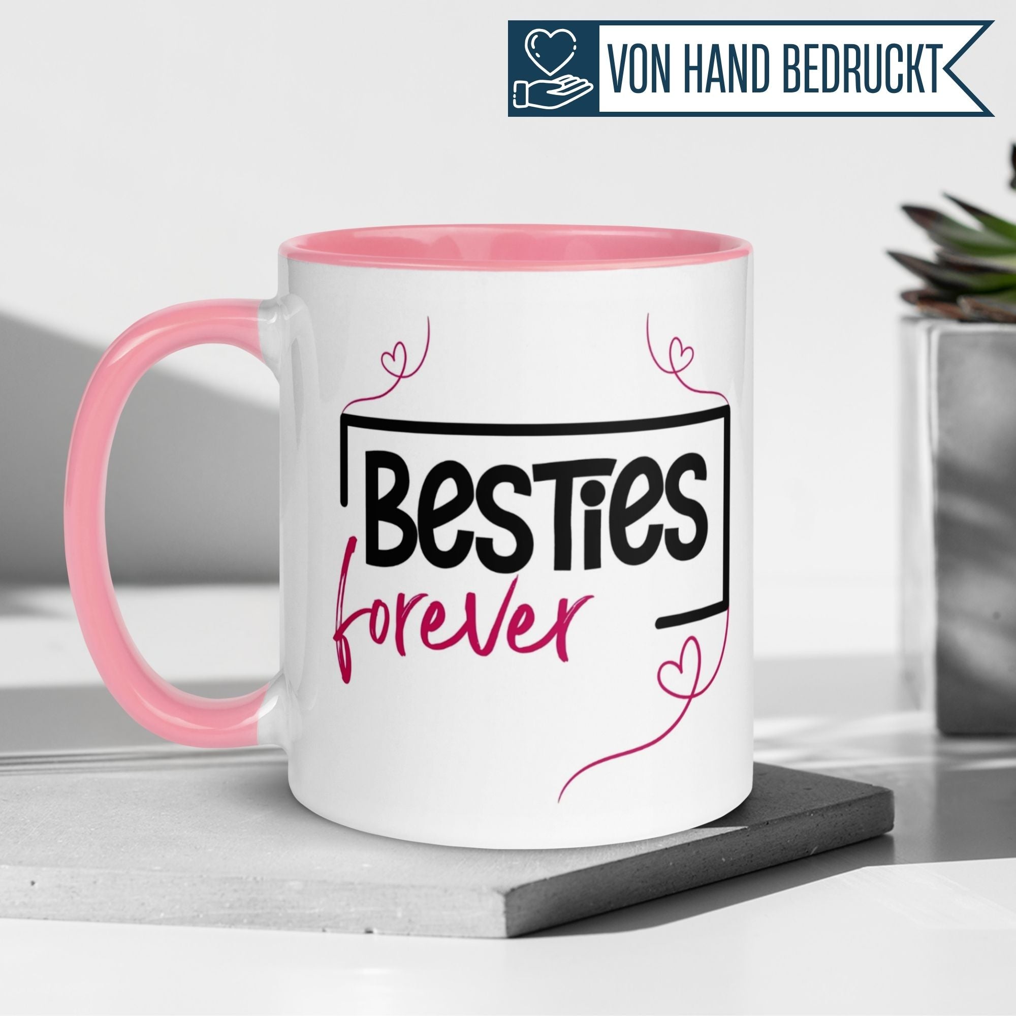 Momentals Tasse mit 'Besties forever' Schriftzug und Herzlinie, pinker Henkel, ideales Geschenk für Freunde.