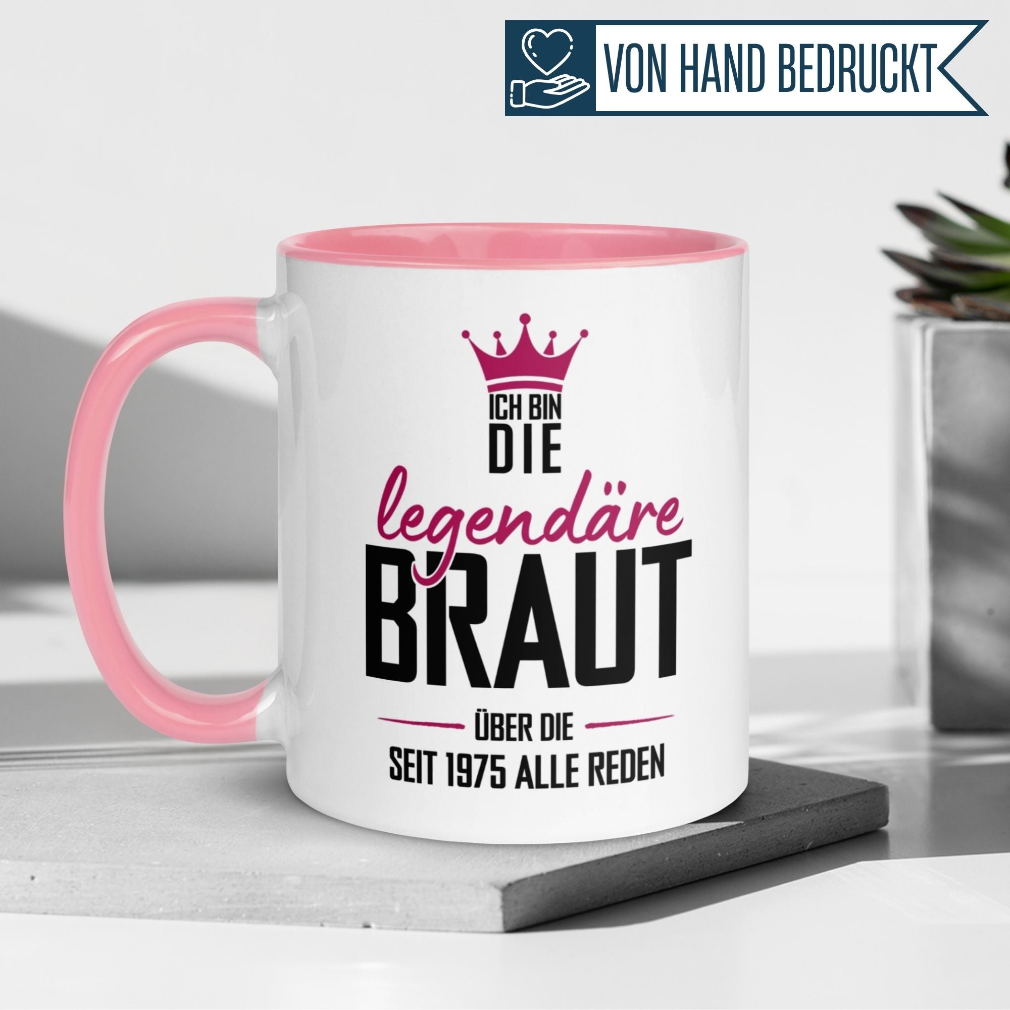 Momentals® Tasse für den 50. Geburtstag, witziger Spruch "Ich bin die legendäre Braut seit 1975" auf rosafarbenem Henkel.