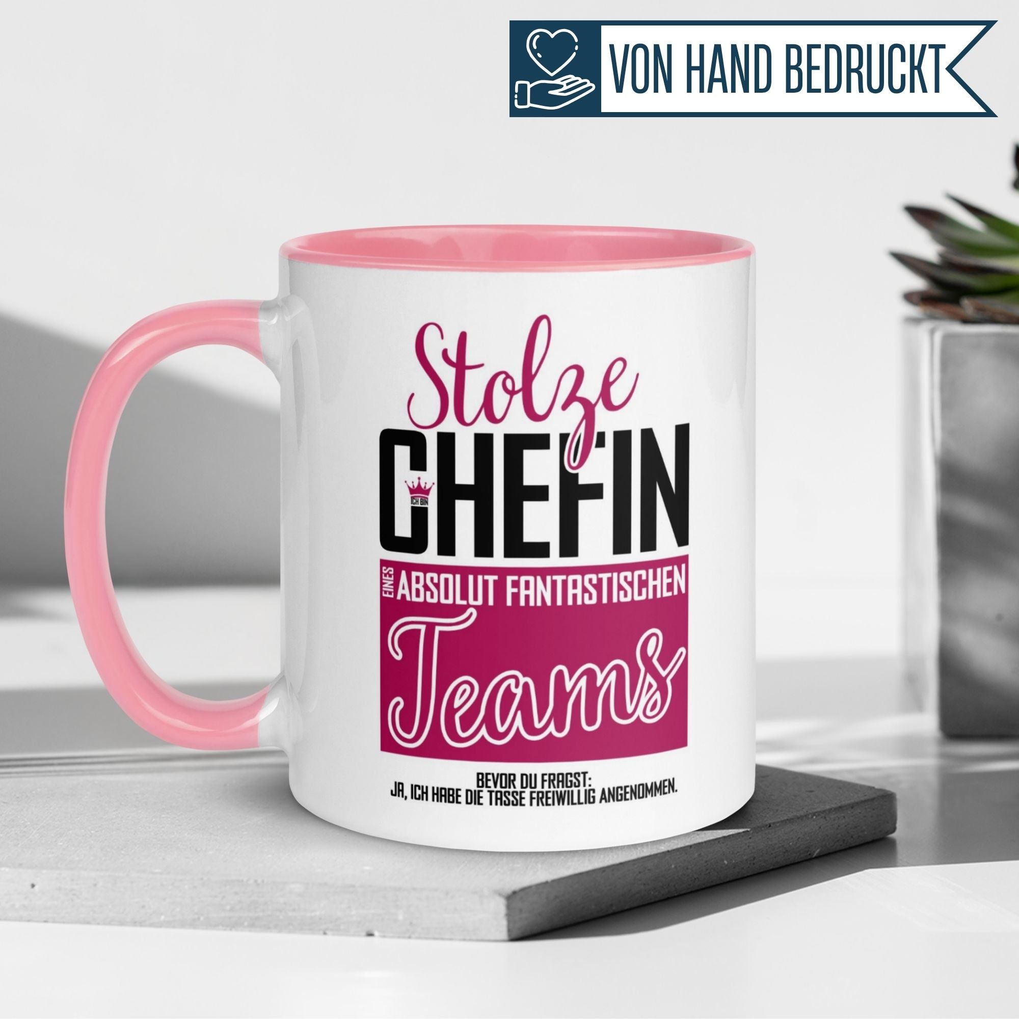 Momentals® Tasse für Chefin mit Spruch "Stolze Chefin eines absolut fantastischen Teams" in Pink und Weiß.