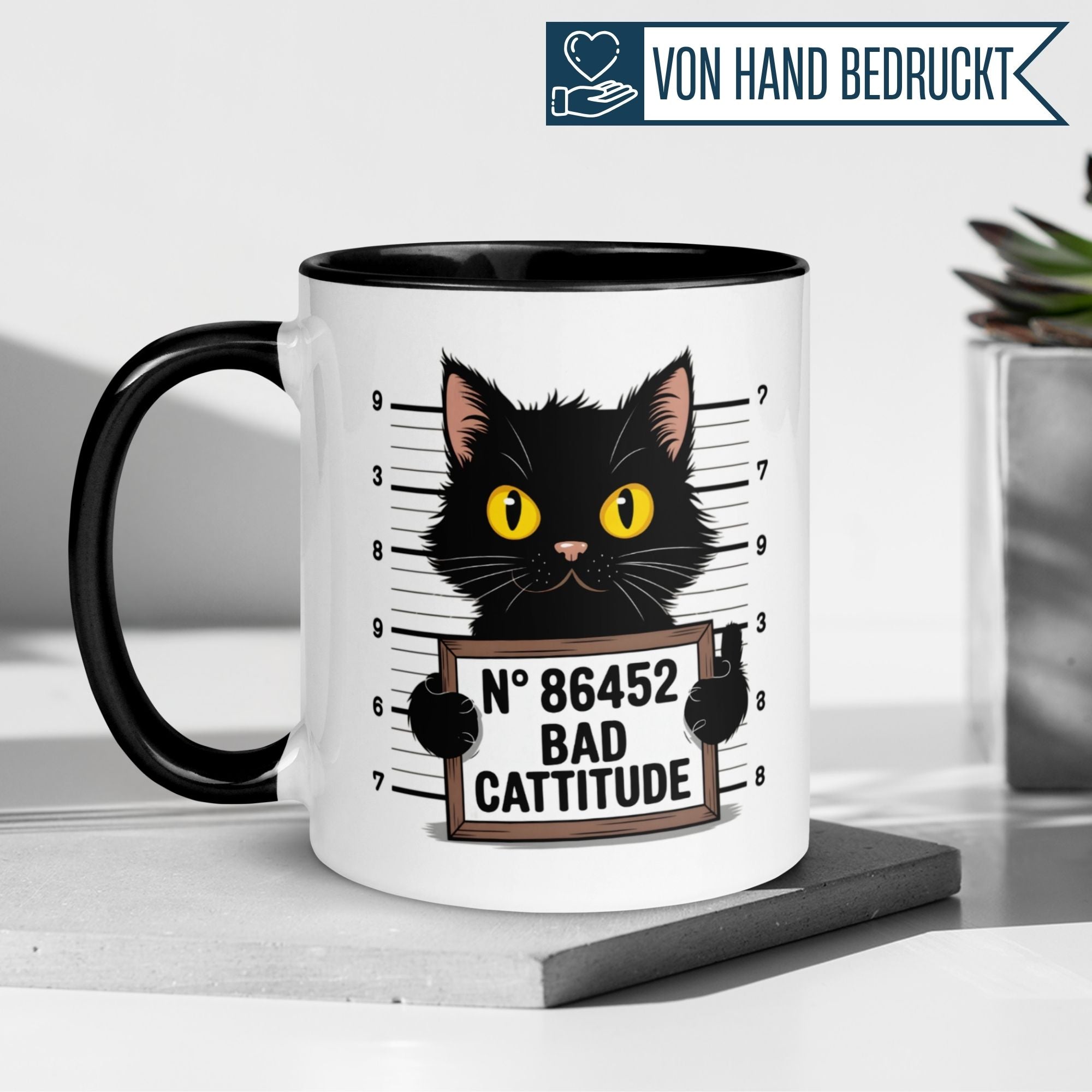 Momentals® Tasse mit frecher schwarzer Katze im Mugshot-Stil und dem Spruch 'Bad Cattitude'