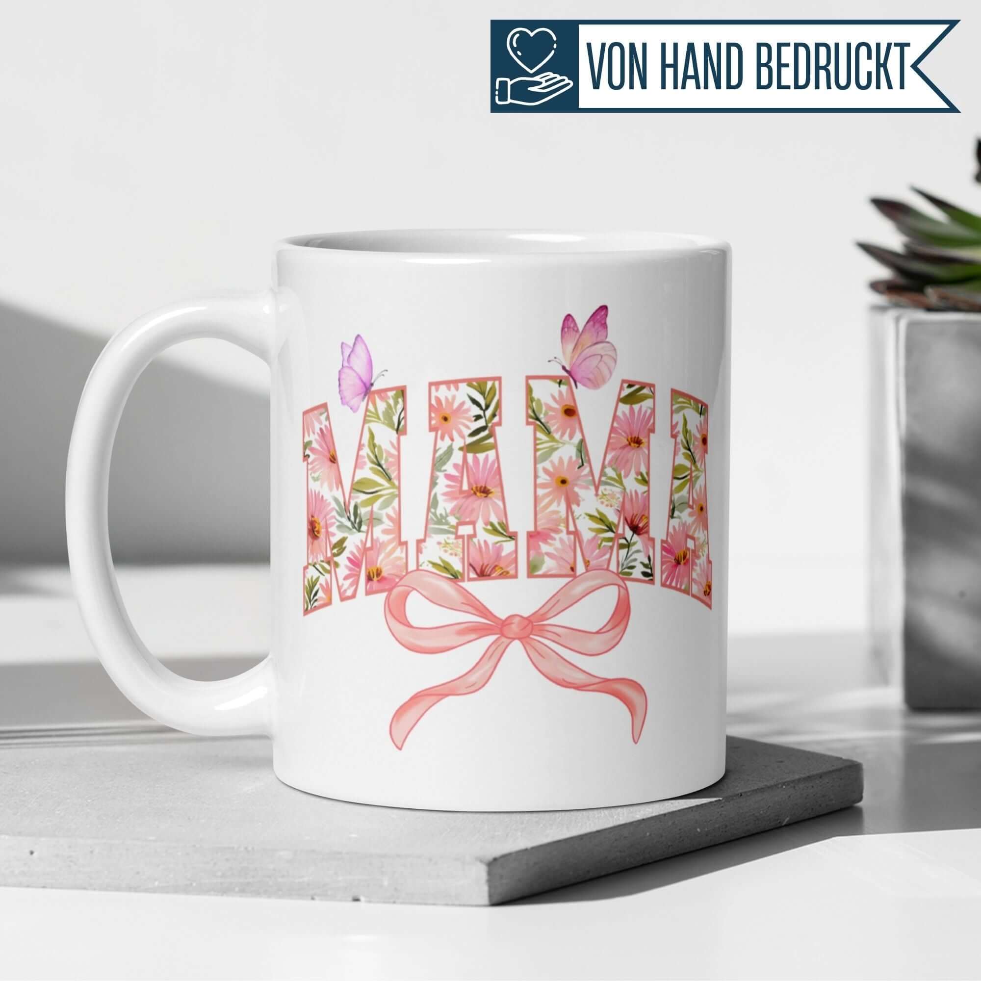 Momentals® Mama Tasse mit bunten Blumen, Schmetterlingen und rosa Schleife, perfekt für Mamas.