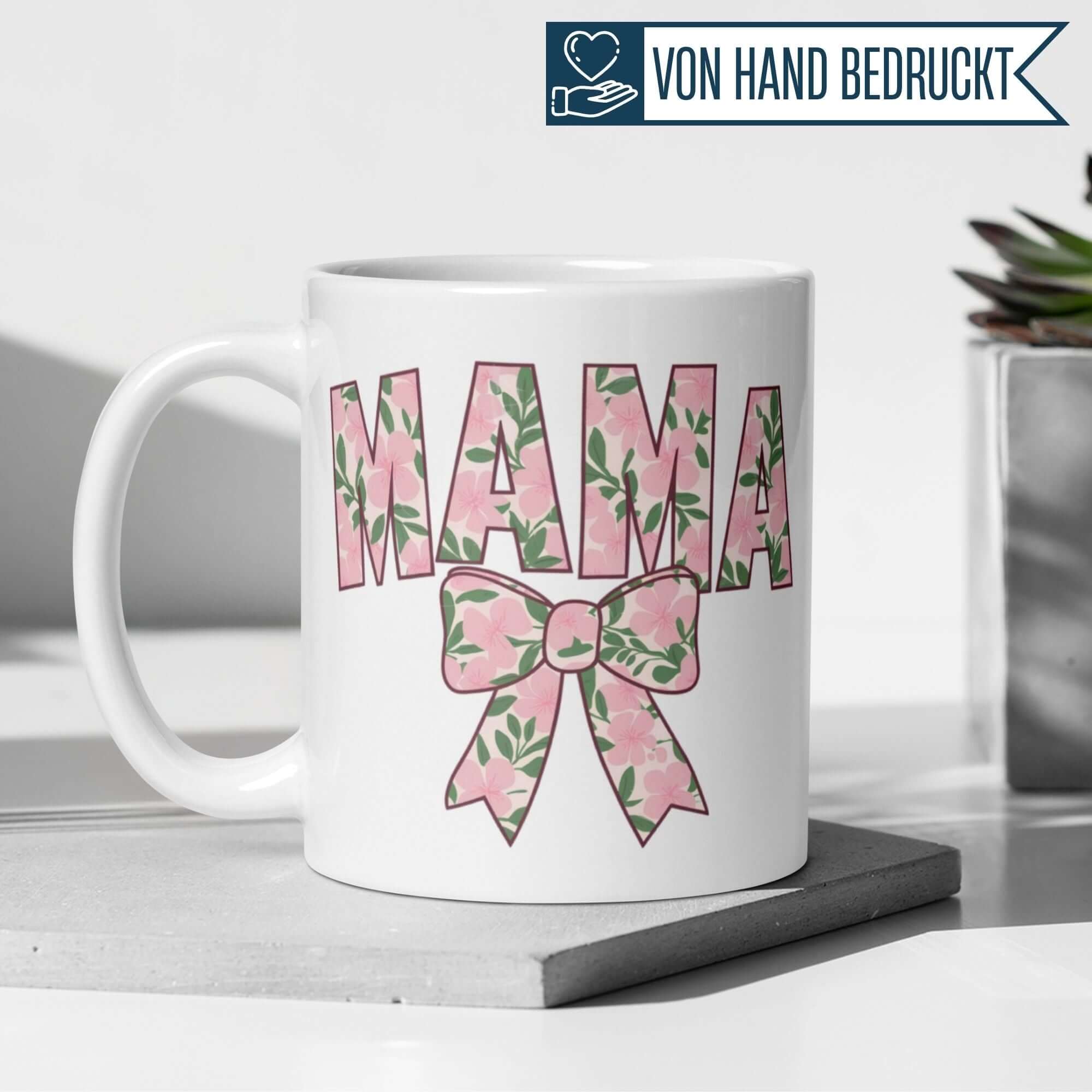 Momentals® Tasse mit floralen Mama Schriftzug und eleganter Blumen Schleife, perfekt für Mamas.