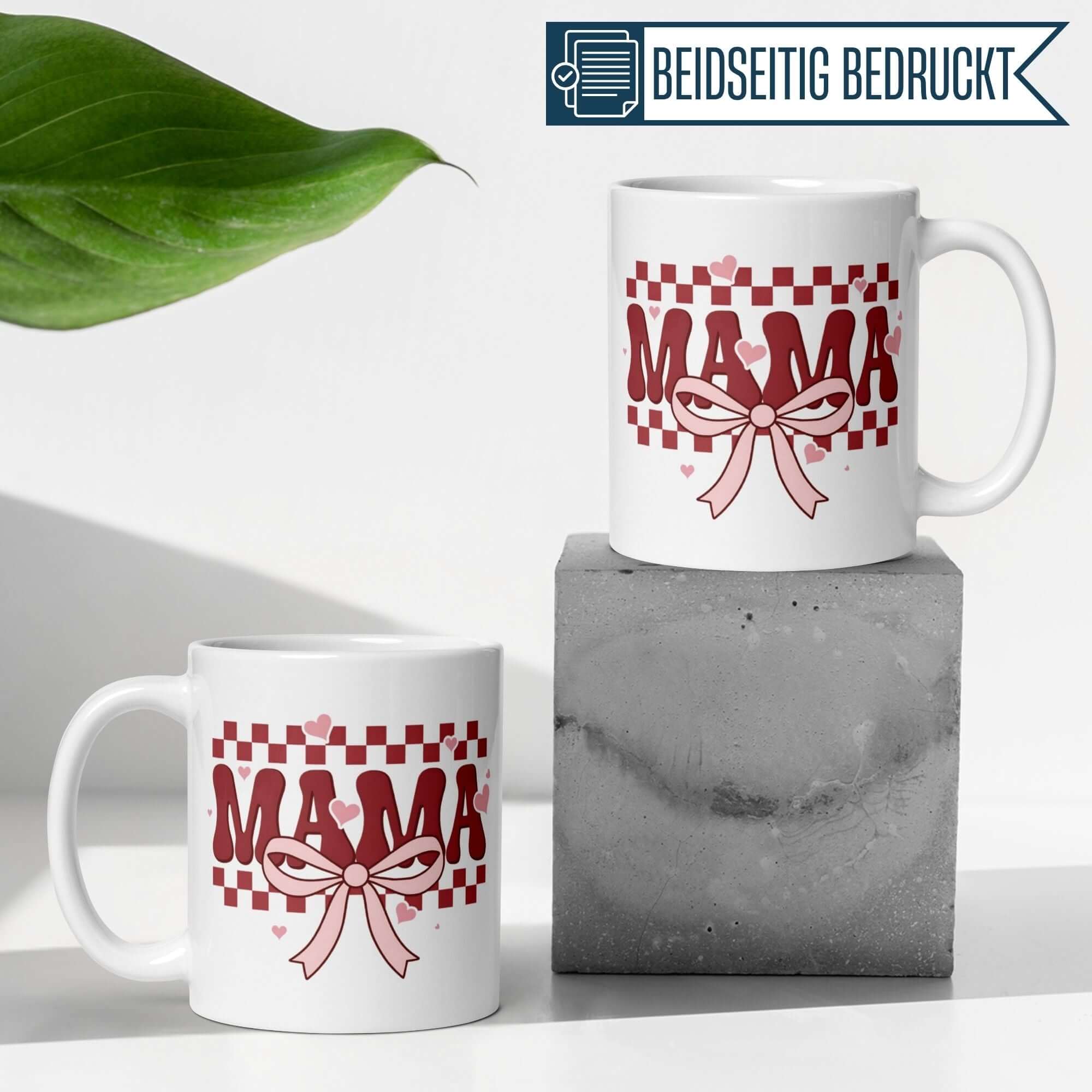 Momentals® Mama Tasse mit Herzen und Schleife, Retro Rot-Rosa Design auf einem modernen Frühstückstisch.