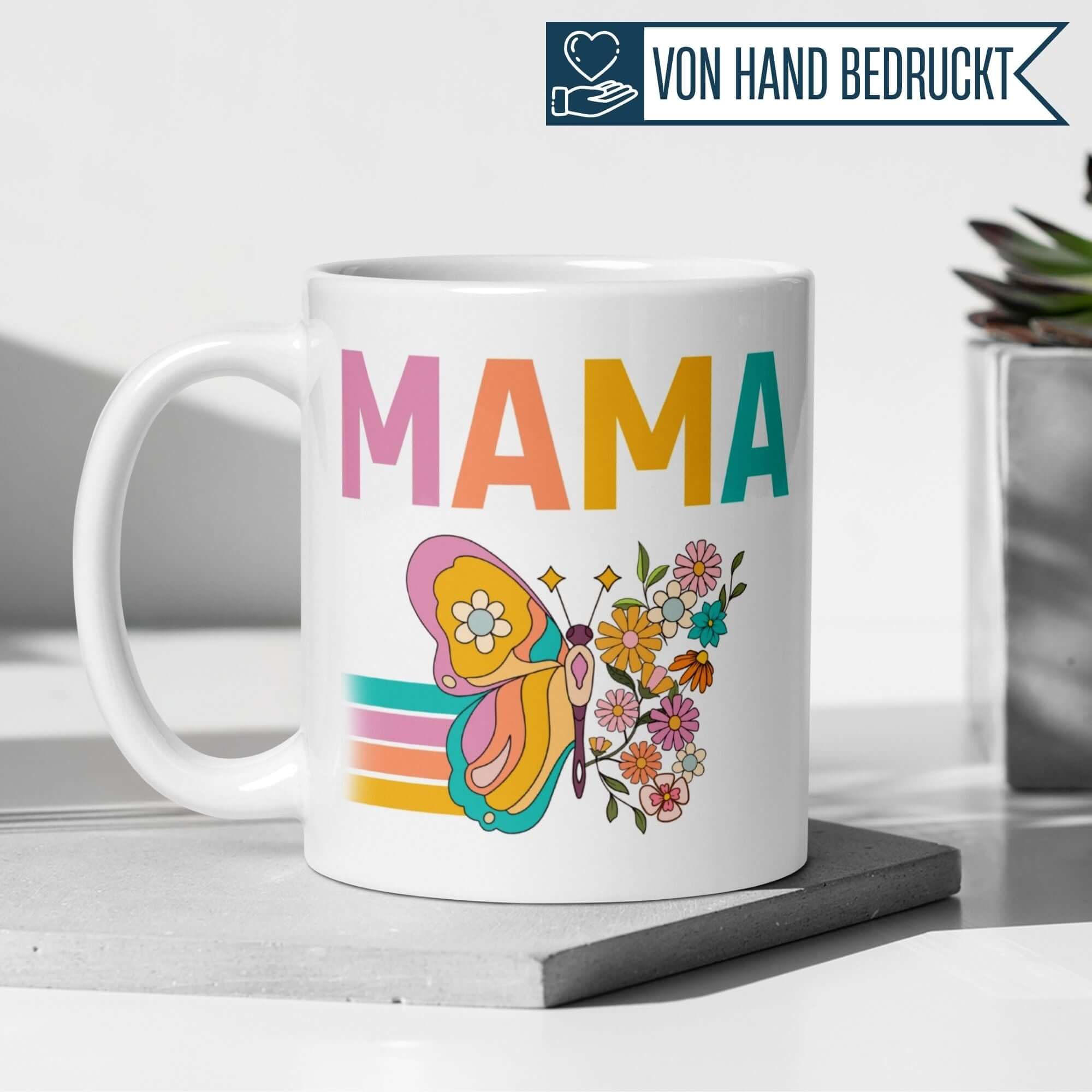 Bunte Tasse mit 'Mama' Schriftzug, Schmetterling und Blumen, perfekt für Geschenke oder den eigenen Kaffeetisch.